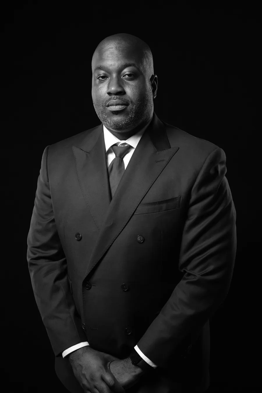 C. Patrick Ngwolo standing in a Houston stairwell, black-and-white portrait